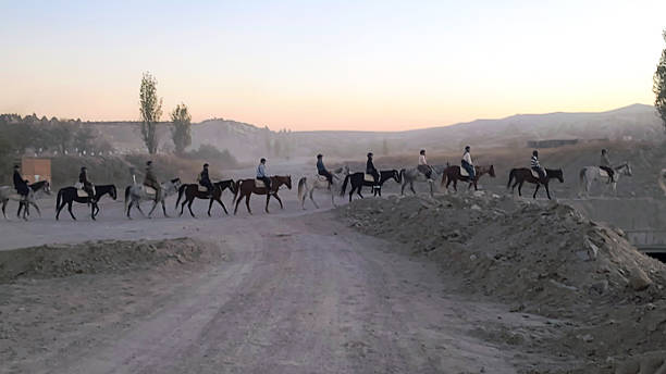 A group riding horses on a dirt road in Cappadocia
