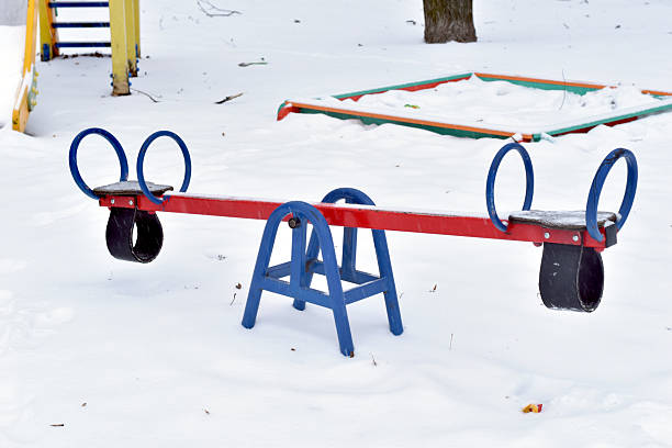 Winter. The fallen snow covered the playground and swings.