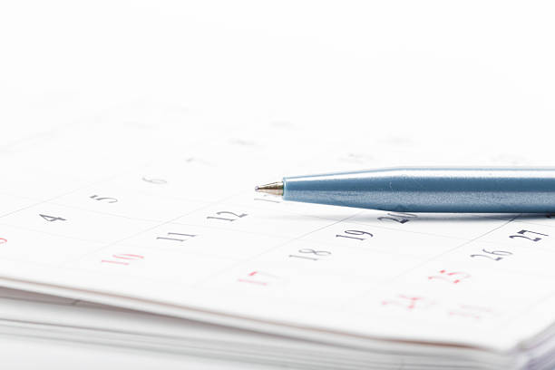 Black business pen on calendar background. Appointment planning work schedule.