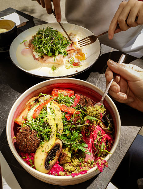 colorful vegan bowl with falafel Breakfast. Sandwich with ham, poached egg, onion and arugula in a plate
