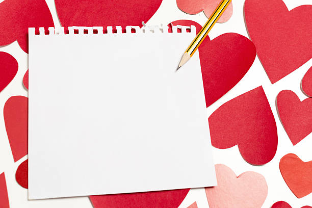 A blank notepad sits amid red paper hearts, inviting users to express love or creativity.