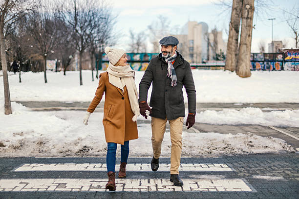 istock Couple holding hands walking on crosswalk in winter 2255901247