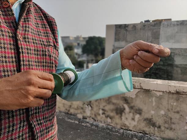 Picture of hands of a person holding a kite string reel preparing for kite flying