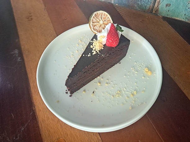 Devil Choco Cake with premium dark cocoa, strawberry, dried lemon slices, mint leaves and a sprinkle of white chocolate. Dessert Menu.