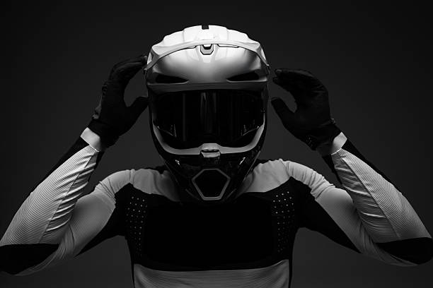 Portrait of a handsome men holding helmet in his hands and sitting on their sport motorcycle in the middle of the road. Sport life and hobbies concept.