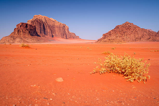 Red sand on Wadi Rum desert on a hot day with mountains, Jordan. Natural wilderness landscapes of the Middle East.