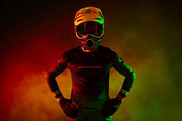 Professional full face helmet with goggles mask lies on a rock against the backdrop of a mountain landscape in the mountains on a sunny day. Used helmet for mountain biking and moto sports. Copy space