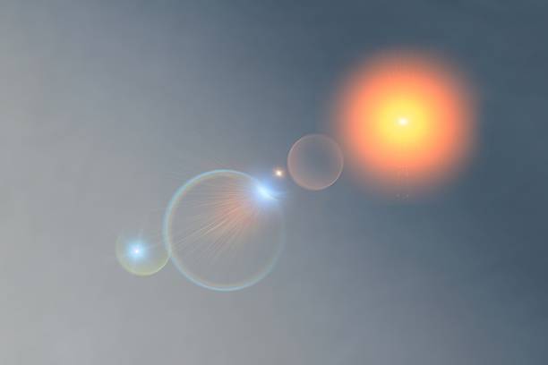 Abstract sky background featuring a warm glowing sun with colorful lens flare circles and soft light rays, creating a dreamy, atmospheric, and cinematic visual mood.