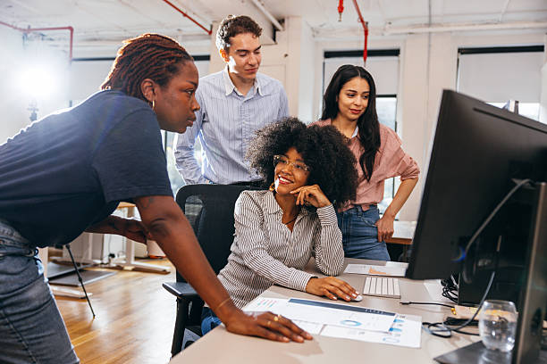 istock Startup employees working together at computers in open office 2255916294