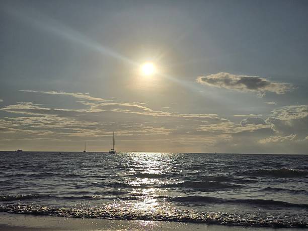The evening sun casts its light over the ocean along the beach, Nadi, Fiji