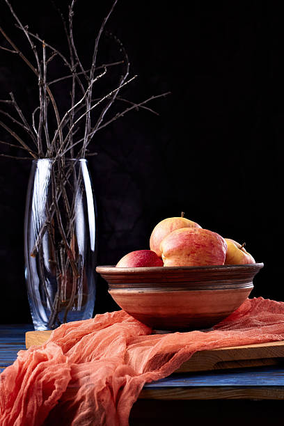 istock Red apples on a clay plate and gauze on a dark background 2255920505