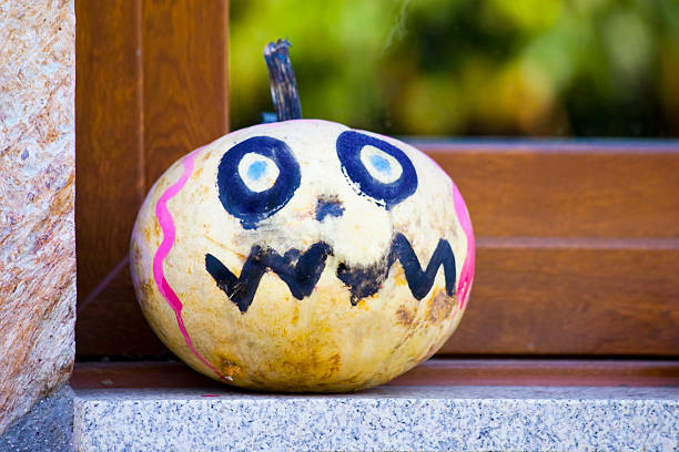 Painted Jack-o-Lantern Pumpkin figurine, rustic close-up view on window sill. Halloween decoration. Galicia, Spain. Monster shape, scary.