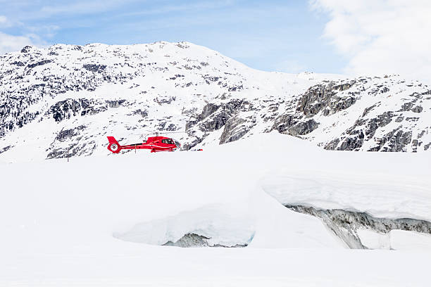 Alpine helicopter flies over glacier in winter, Pemberton, B.C.