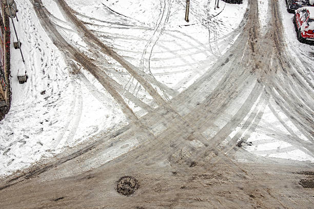 Urban city street during winter with snow on ground and visible tyre tracks