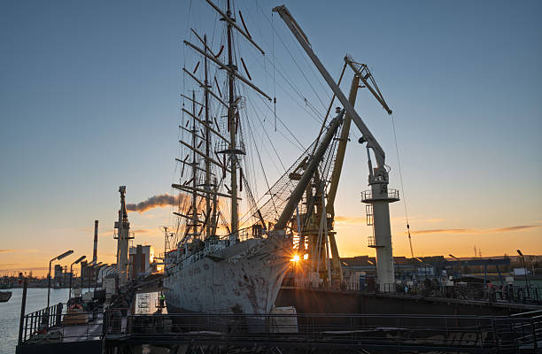 three-masted sailing ship in dry dock during repairs at the shipyard