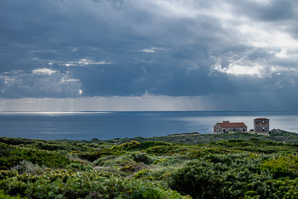Sesimbra Portugal December 25 2025. Abandoned observation buildings sit on coastal scrubland overlooking the Atlantic Ocean at Cabo Espichel.