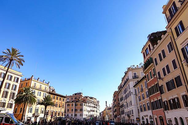 Piazza di Spagna - Rome, Italy - Spanish steps. The Spanish Scalinata di Trinita dei Monti steps in Rome, Italy full with tourists enjoying the sunny day and beautiful architecture and taking photos. View of Trinita  dei Monti church.