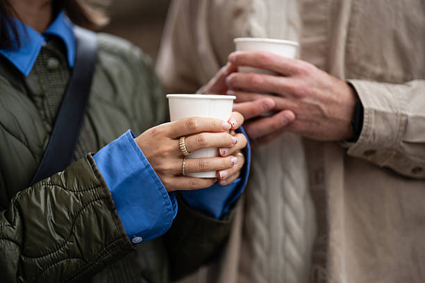 Couple hands holding coffee cups together