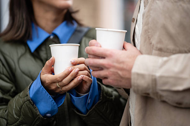 Couple sharing take away coffee cups outdoors