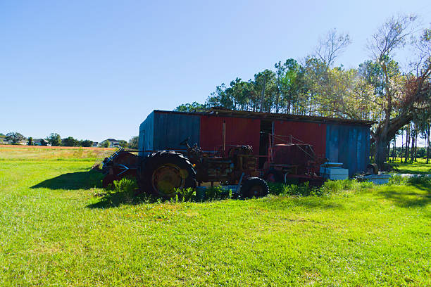 New Smyrna Beach, FL, USA, Landscape, some rusty tractors and an abandoned shed in the field.