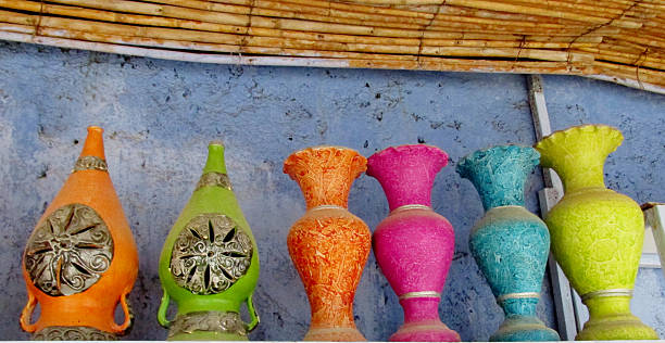 Clay decorative pots in Moroccan traditional style with intricate patterns, earthy colors, and handcrafted details. Cultural artisan objects showing North African craftsmanship, home decoration, pottery design, ornamental ceramics, and traditional market environment