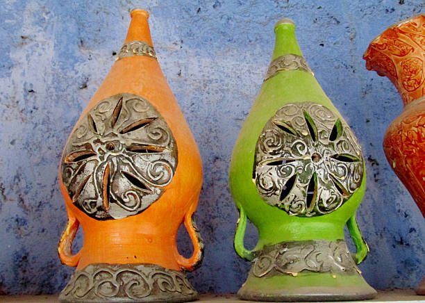 Clay decorative pots in Moroccan traditional style with intricate patterns, earthy colors, and handcrafted details. Cultural artisan objects showing North African craftsmanship, home decoration, pottery design, ornamental ceramics, and traditional market environment