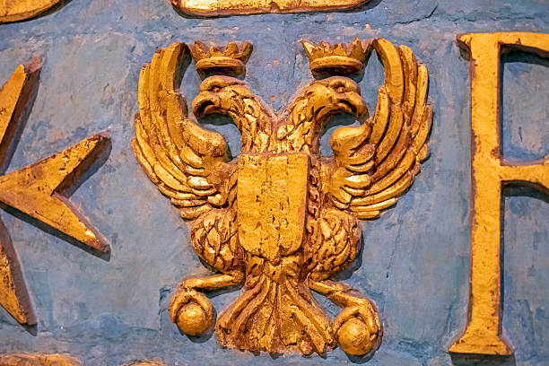 Golden russian double-headed eagle on a blue sky background at sunny day, front view