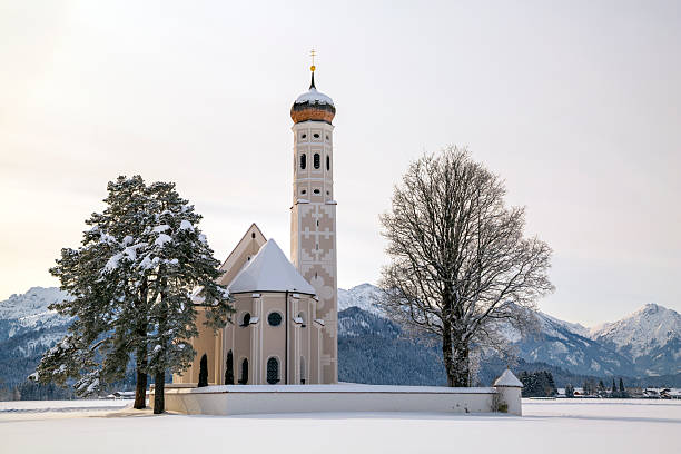 Panoramic view of beautiful winter landscape in the Bavarian Alps with pilgrimage church of Maria Gern and famous Watzmann massif in the background, Nationalpark Berchtesgadener Land, Bavaria, Germany.