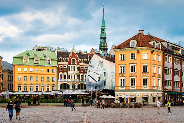 People walk in downtown Riga, Latvia on a cloudy day.