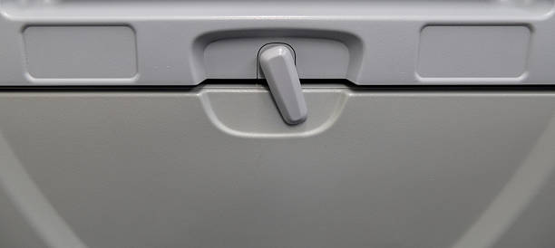tray table stowed on airplane economy class seat below entertainment screen with plug (closed dining close up) in flight meal option airline travel leisure business first class