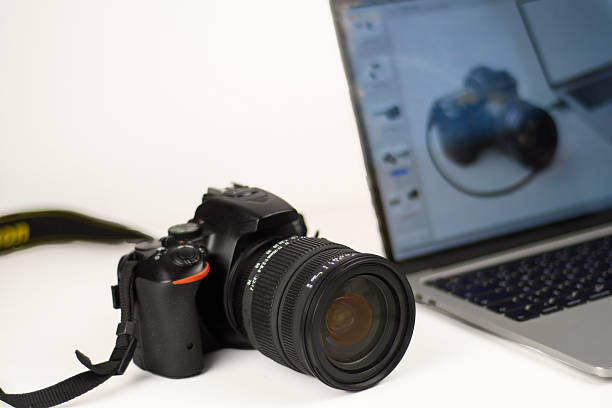 Professional photography setup with DSLR camera and laptop for editing and post-production. Clean white background with copy space for creative business themes.