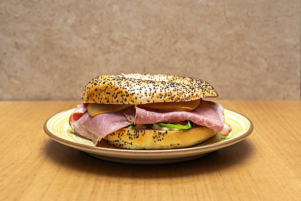 a freshly sliced sesame bagel unfolds its fluffy interior beneath a single, perfect slice of wild salmon and a sprig of dill, celebrating the purity of the ingredients