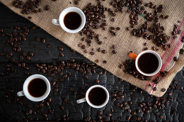 Red cup of coffee and coffee beans on the table