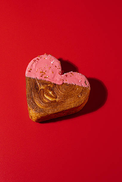 Creative ides Valentine's Day love symbol Holiday celebration Heart shaped flavor croissants on red background with copy space. Puff pastry new trendy sweet dessert bakery. Creamy dough