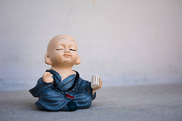 Peaceful monk figurine meditating on textured background