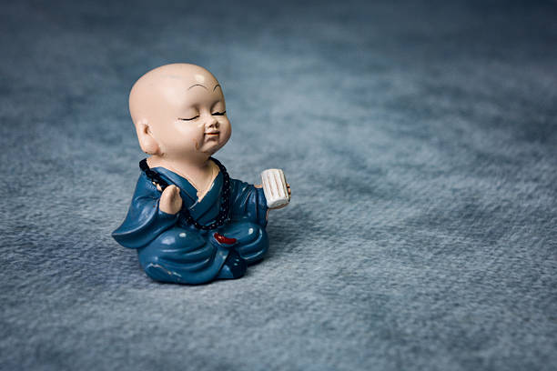 Peaceful monk figurine meditating on textured background
