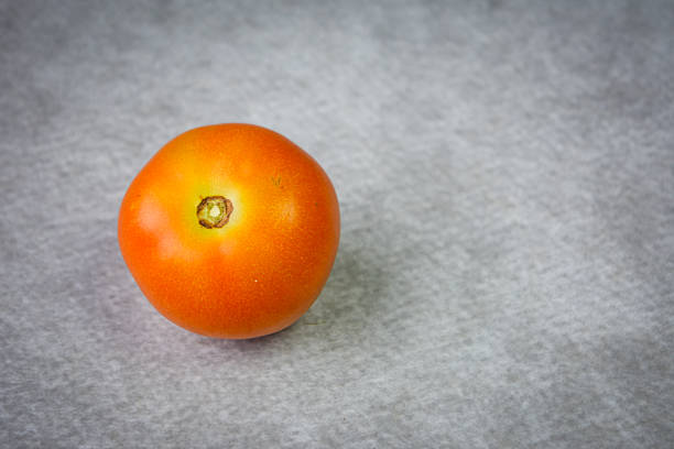 Fresh ripe tomato on textured background. Healthy cooking concept