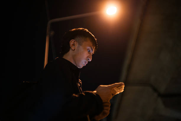 Asian young man using a mobile app to order a taxi.