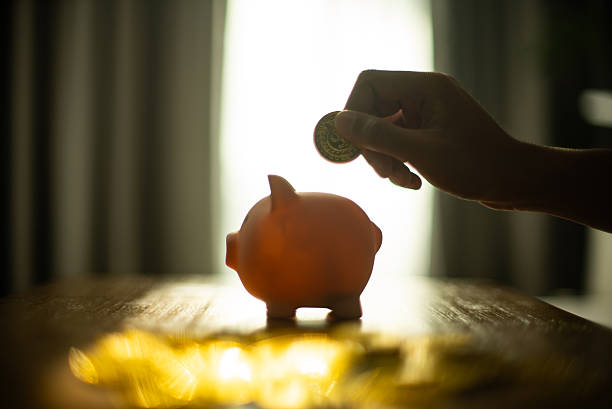 Putting Coins into Piggy Bank for Saving Money Concept.