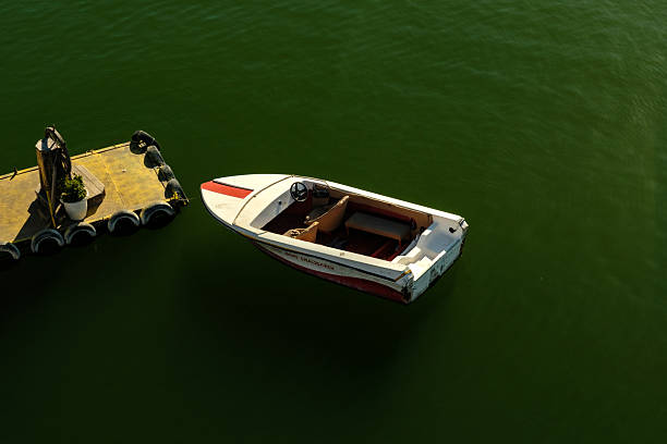 An unmarked luxury yacht speeds out of the Ocean City, MD harbor with the harbor front residences in the background
