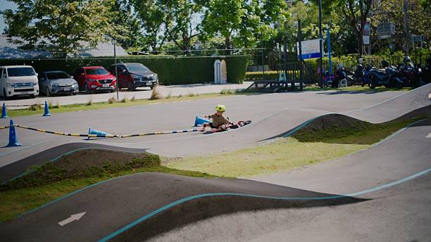 Active Asian boy rides a balance bike on a challenging bumpy track, experiencing a few falls but happily getting back up and continuing. A fun, energetic, and confidence-building outdoor activity for kids.