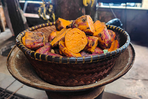 Sweet potatoes in plastic basket isolated on white background representing fresh root vegetables, agricultural produce, food supply, and everyday cooking ingredients in clean minimal presentation.