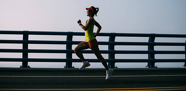 istock Fitness woman runner running on seaside bridge 2256007340