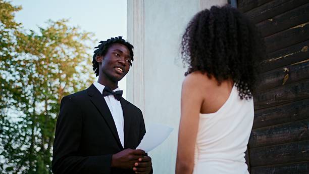 The groom reads the wedding vow looking at the bride with a smile