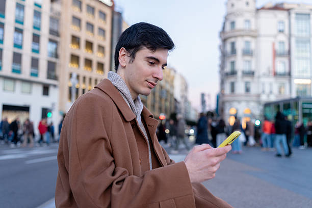 istock Young man using smartphone in winter city street 2256014989