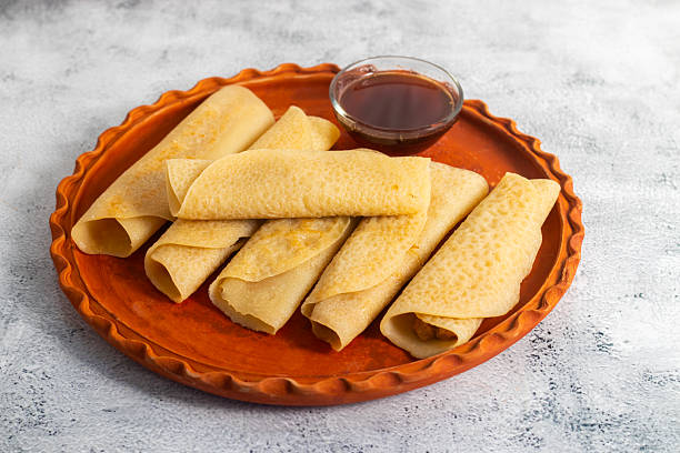 Patishapta Pitha, a Traditional Bengali dessert featuring thin rice flour crepes filled with sweet coconut, jaggery, or khoya, gently folded and served warm during festivals, celebrations, winter.