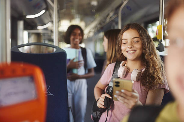 istock Happy schoolgirl using cell phone while traveling to school in a bus. 2256020290