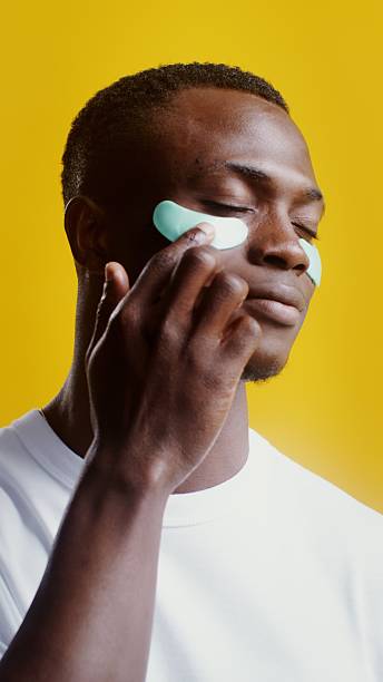 istock A man corrects moisturizing patches under his eyes - Care. 2256022793