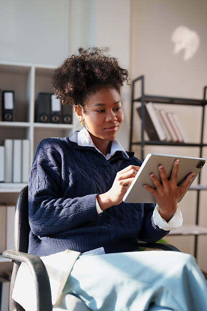 istock Young Black woman focused on a digital tablet, managing tasks and staying productive while working remotely from a modern office or home workspace, connected and professional 2256026817