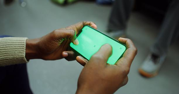 Mobile phone with green screen in men's hands in the subway